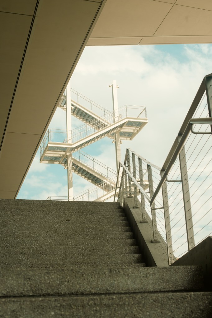 Photograph of two sets of concrete stairs with a blue sky in the background